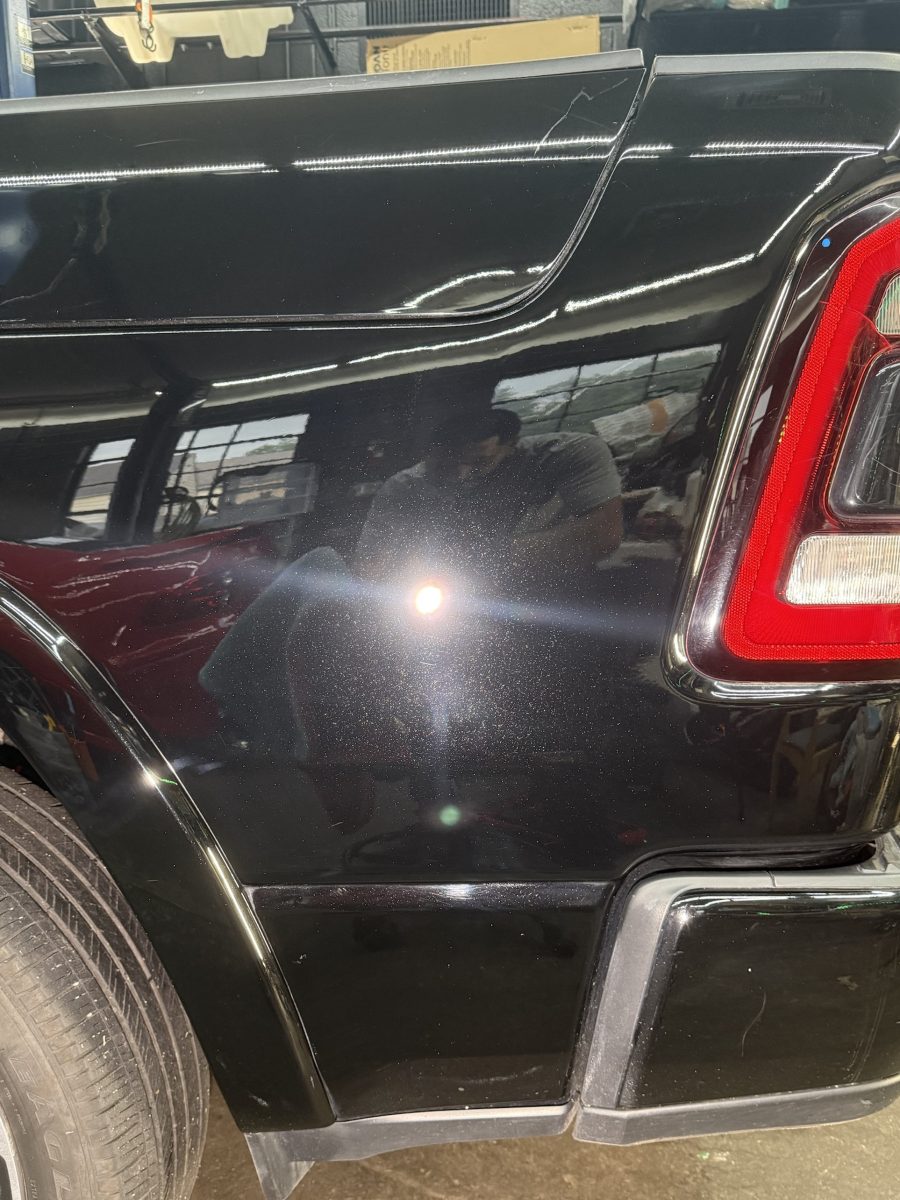 After: the same black truck panel corrected and coated, with a deep, swirl-free mirror finish